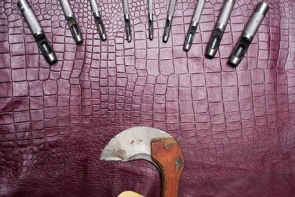 Herramientas artesanales de cuero sobre un fondo de cuero. Escritorio de trabajo artesano
 - Foto, imagen