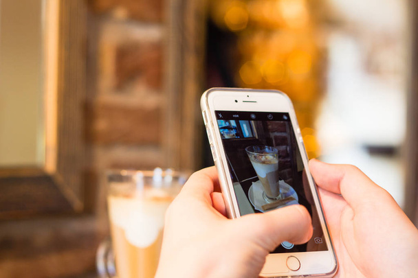 Biorąc obraz kawy latte z smartphone - Zdjęcie, obraz