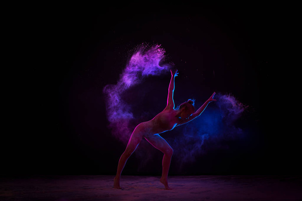 Graceful girl dancing in color powder cloud - 写真・画像