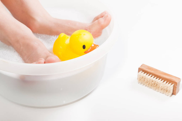 Garçon pieds dans le bain alimentaire avec canard en caoutchouc
 - Photo, image