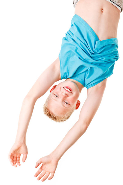 Poika leikkii ja roikkuu ylösalaisin
 - Valokuva, kuva