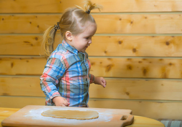 cute child in checkered shirt cooking with dough and flour - Φωτογραφία, εικόνα