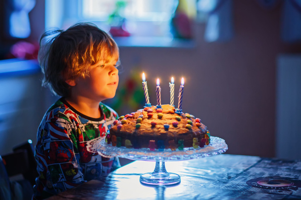 Petit garçon enfant célébrant son anniversaire et soufflant des bougies sur gâteau
 - Photo, image
