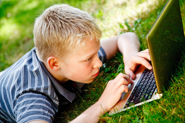 Junge spielt draußen mit Computer - Foto, Bild
