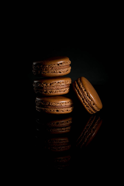 Sweet and colorful french macaroon or macaron on black background - Photo, image