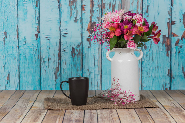 Bouquet di fiori in vaso bianco vintage in ambiente rustico con
  - Foto, immagini