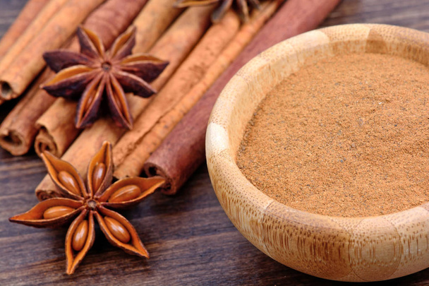 Cinnamon with anise star on wooden background - Фото, зображення