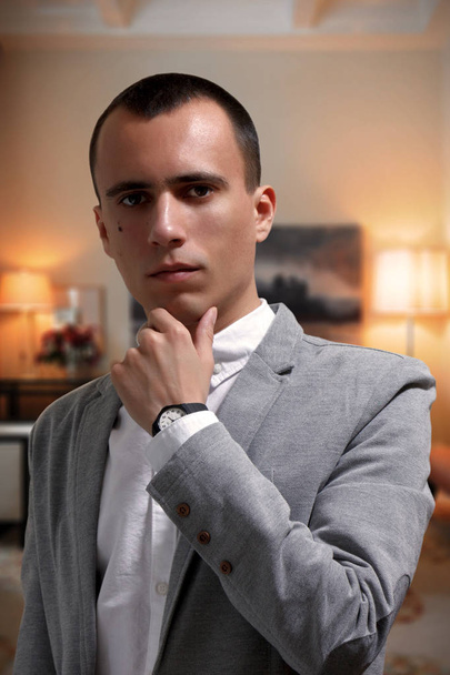 Retrato de un hombre de negocios joven y bien parecido en chaqueta gris y camiseta blanca, mirando a la cámara
 - Foto, Imagen