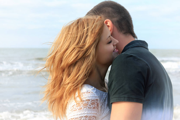 Blond and brunette teen couple hug together in beach outdoor at summer vacation - Foto, Bild