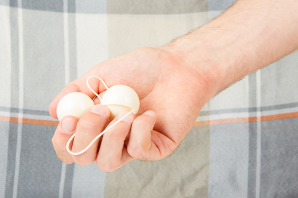 Рука с белыми вагинальными шариками, изолированными
 - Фото, изображение