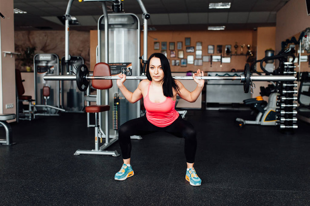 Beautiful fitness woman lifting barbell. - Fotó, kép