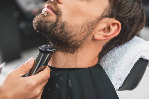 Barber leveling human stubble by shearer - Photo, Image