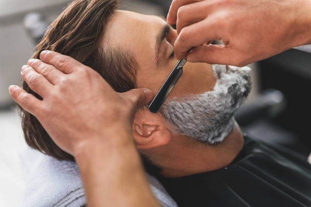 Professional barber getting rid of male stubble - Fotoğraf, Görsel