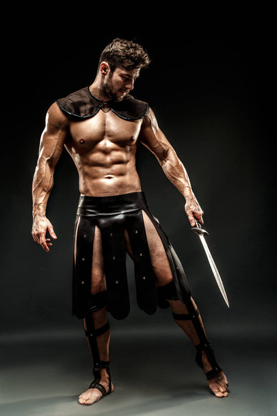 Severe barbarian in leather costume with sword - Φωτογραφία, εικόνα
