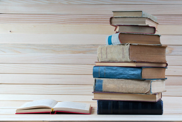 Libro abierto, pila de libros de tapa dura sobre mesa de madera
. - Foto, Imagen