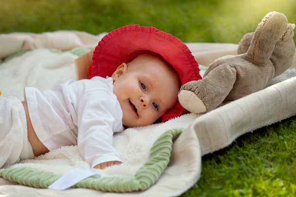 Cute little baby girl playing with her toys in the garden - Foto, Bild