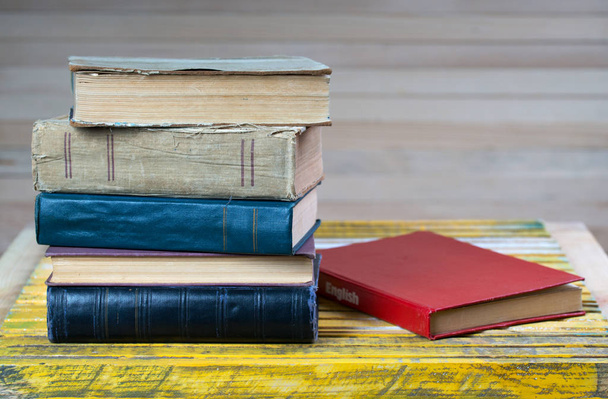Montón de libros de tapa dura sobre mesa de madera. Libro de texto en inglés
. - Foto, Imagen