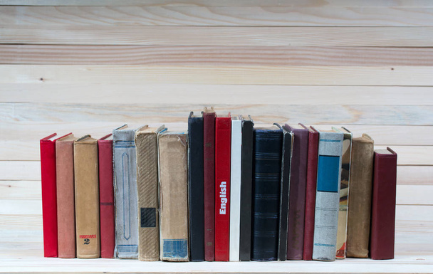 Στοίβα από βιβλία hardback στο ξύλινο τραπέζι. Αγγλικό εγχειρίδιο. - Φωτογραφία, εικόνα