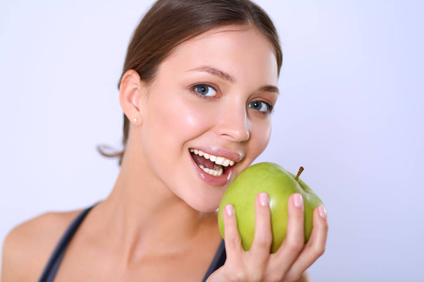 Happy young woman eating apples, isolated on white background - Valokuva, kuva