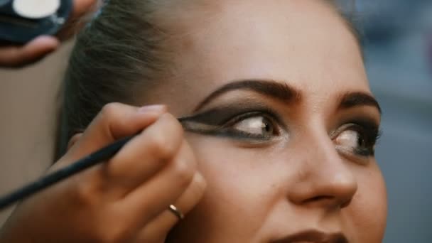 tvoří umělec dělá profesionální make-up mladé ženy - Záběry, video
