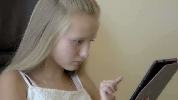 closeup of Teenager girl sitting and playing with tablet - Filmati, video