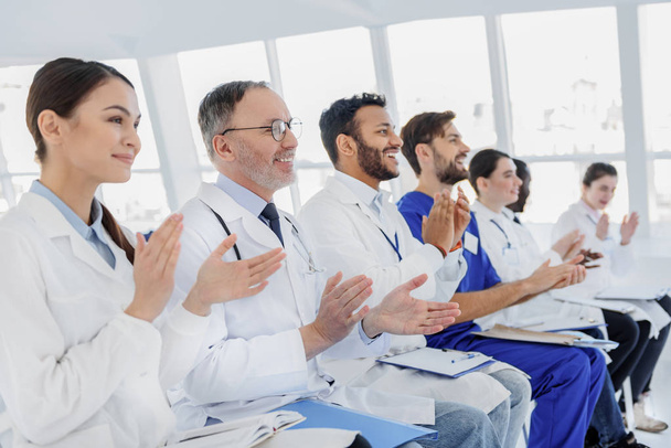 Joyful medical team clapping hands - Фото, изображение