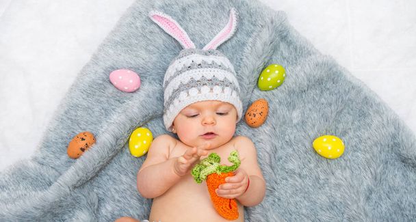 Bébé fille en chapeau de lapin couché sur couverture grise
 - Photo, image