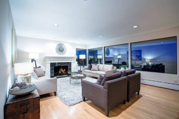 Теплая коричневая гостиная с панорамным видом на окно
.  - Фото, изображение