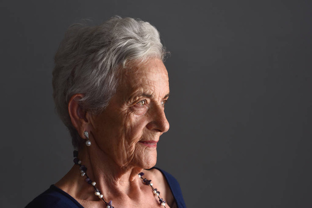 retrato de una mujer mayor sobre fondo gris
 - Foto, Imagen