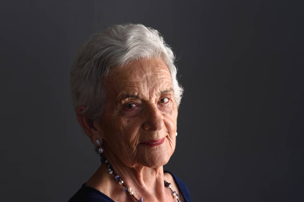retrato de uma mulher idosa em fundo cinza
 - Foto, Imagem