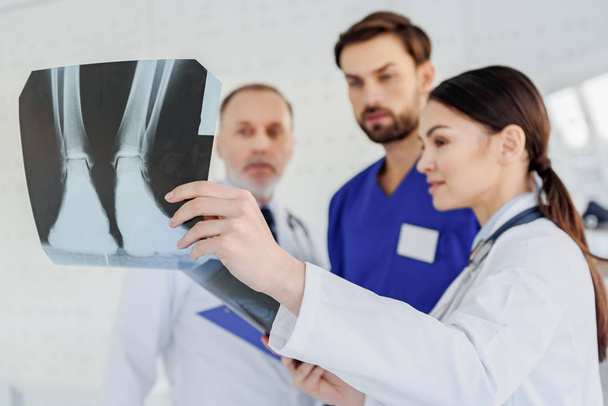 Skillful doctors analyzing x-ray photo - Фото, изображение
