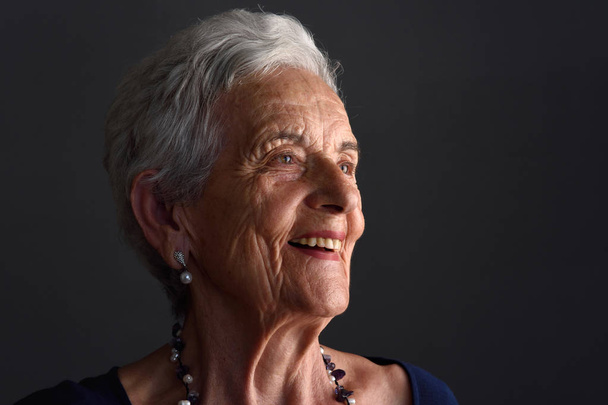 retrato de una mujer mayor sobre fondo gris
 - Foto, imagen