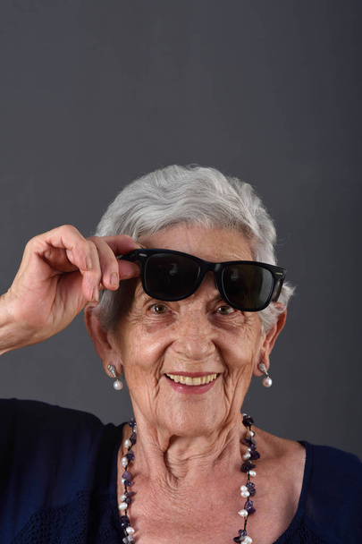 Portrait of a senior  woman with glasses on forehead - Photo, Image