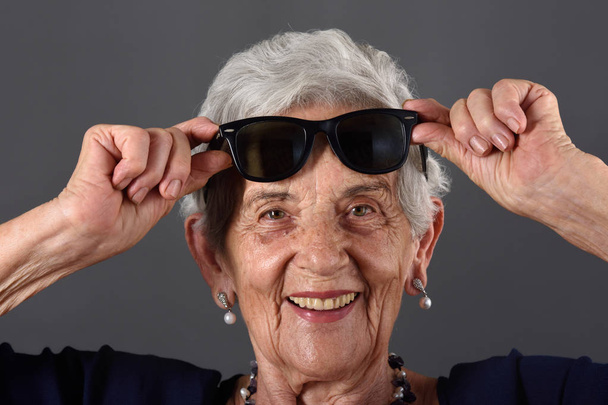 Portrait of a senior  woman with glasses on forehead - Foto, afbeelding