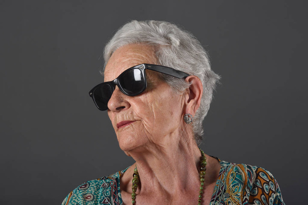 Ritratto di donna anziana con occhiali sfondo grigio
 - Foto, immagini