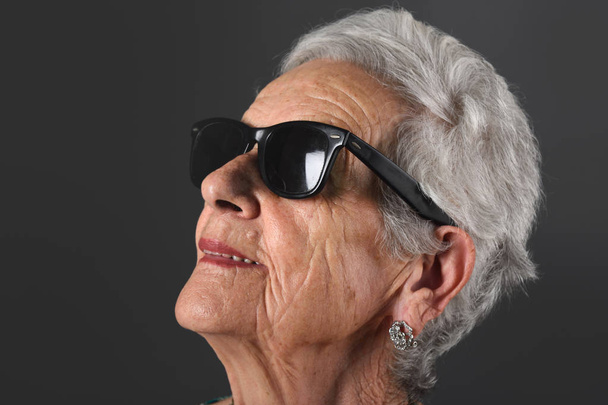 Портрет старшої жінки в окулярах сірого фону
 - Фото, зображення