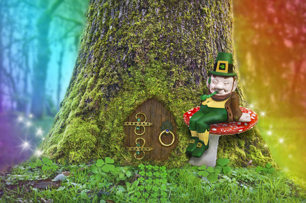 Leprechaun sitting on a mushroom in forest with rainbow and fairy lights - Photo, Image