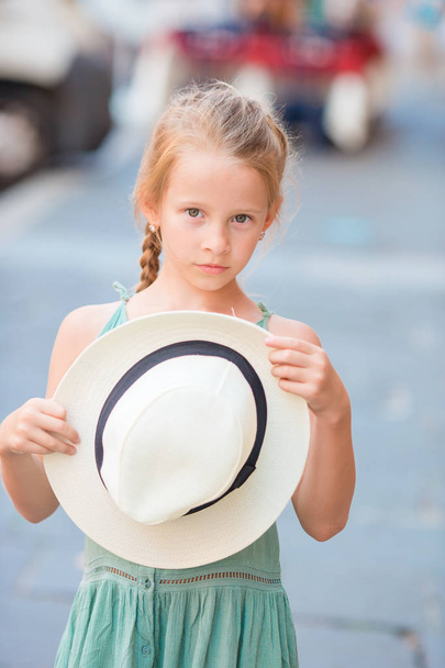 Suloinen iloinen pieni tyttö ulkona Euroopan kaupungissa. Muotokuva valkoihoinen lapsi nauttia kesälomasta Roomassa
 - Valokuva, kuva