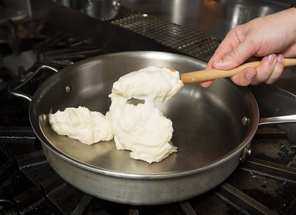 Preparing solid cheese in a pan, for Macaroni cheese - Φωτογραφία, εικόνα