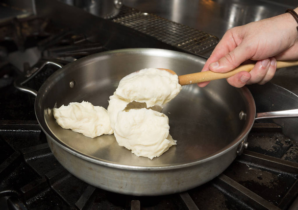 Preparing solid cheese in a pan, for Macaroni cheese - Φωτογραφία, εικόνα