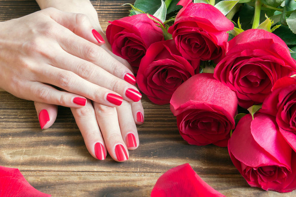 červené nehty manikúra s červenou růží a okolí - Fotografie, Obrázek