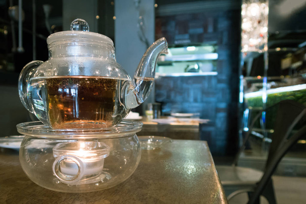 Стеклянный чайник на столе в кафе
 - Фото, изображение