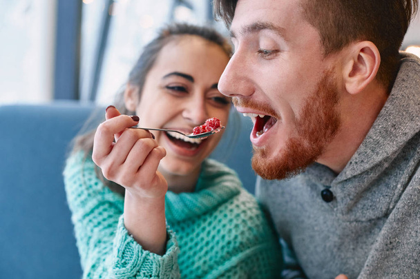 couple eating a dessert spoon in cafe on date - Photo, image