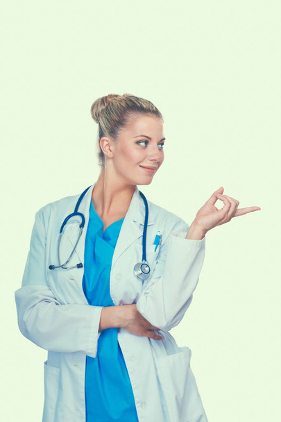Fiatal orvos nő sztetoszkóppal mutat valamit, elszigetelt fehér alapon - Fotó, kép