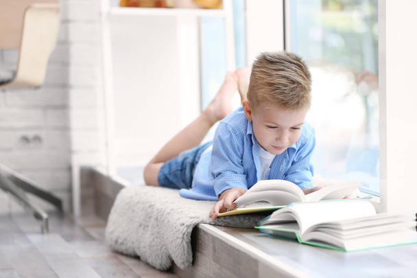 Cute boy reading interesting book   - Foto, Imagen