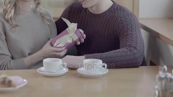 Beautiful girl holds a box with a gift from the boyfriend. He hugs her - Materiał filmowy, wideo