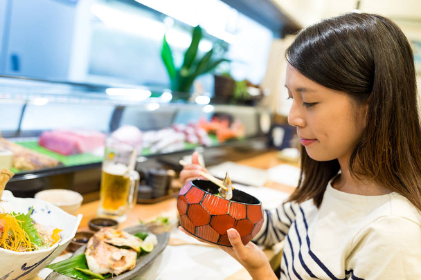 Mulher desfrutar de seu jantar no restaurante japonês
 - Foto, Imagem