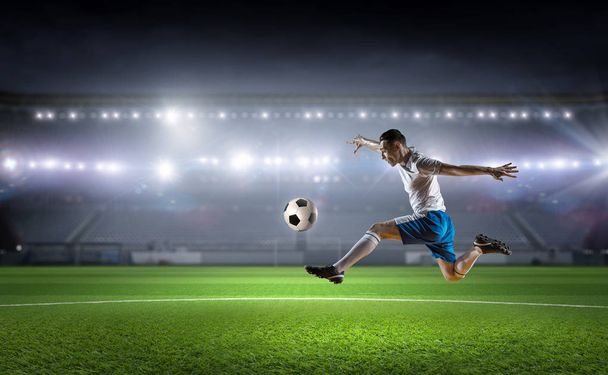 Jalkapalloilija potkii palloa. Sekalaiset tiedotusvälineet
 - Valokuva, kuva