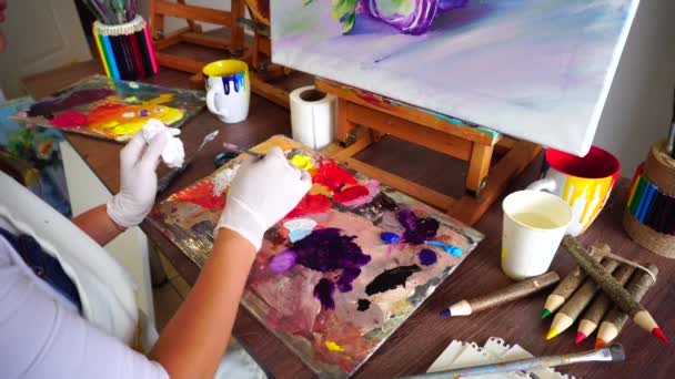 Καλλιτέχνης ανάγλυφα στοιχεία χρώμα από σωλήνες στην παλέτα για ανάμειξη χρωμάτων να ξεκινήσει σχέδιο εικόνες στο Art Studio. - Πλάνα, βίντεο