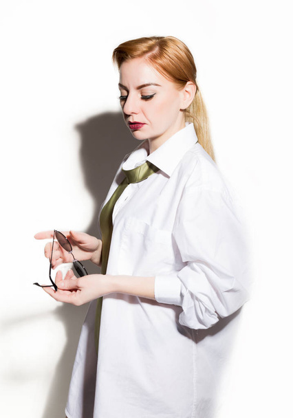 naked young woman in a mans white shirt with green tie holding glasess - Valokuva, kuva